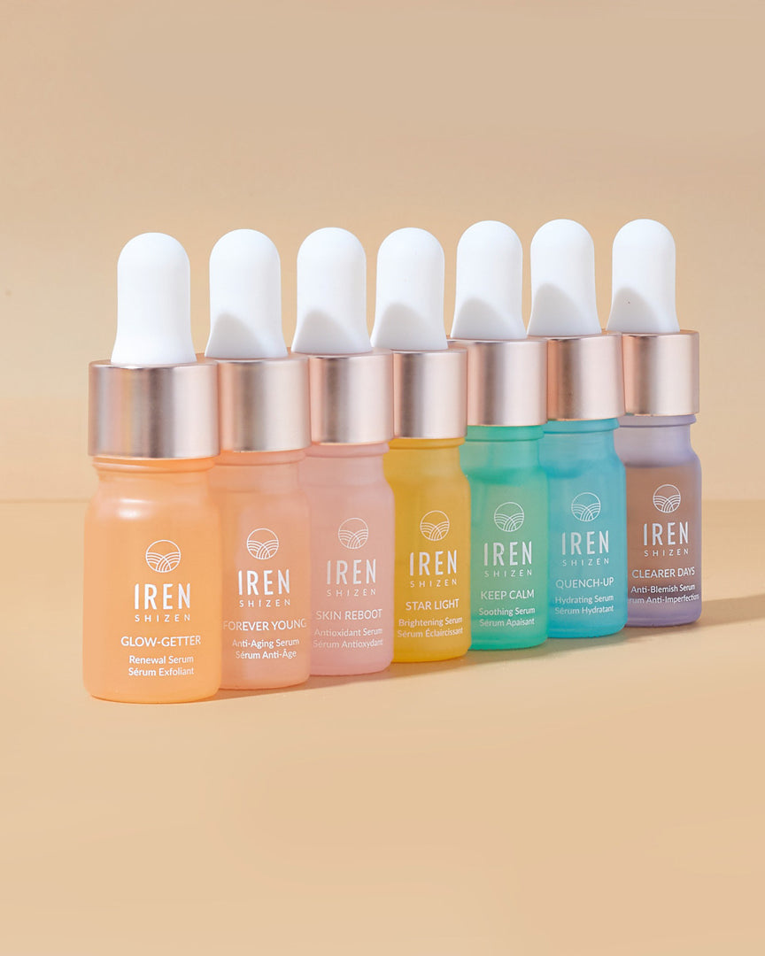 A set of DEW UP Hydrating Discovery Kits with different colored liquids on a beige background from the Japanese skincare brand IREN Shizen.