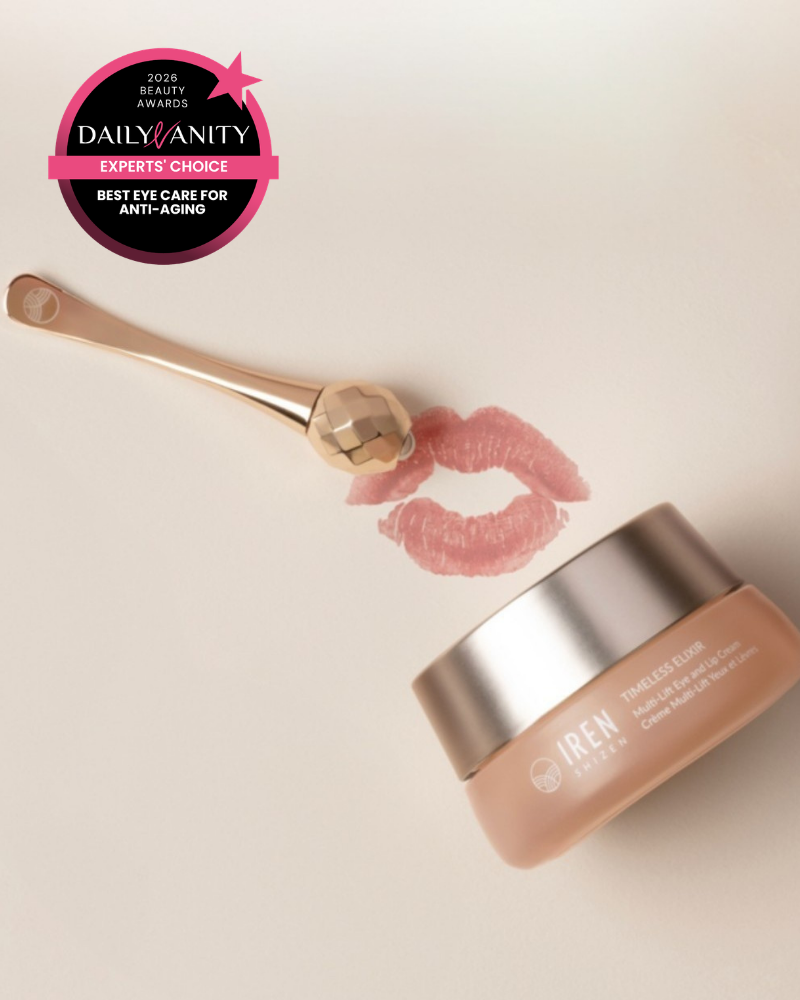A facial roller, a jar of IREN Shizen TIMELESS ELIXIR Multi-Lift Eye and Lip Cream, a lipstick kiss mark, and a 2023 Daily Vanity Best Eye Care for Anti-Aging award badge are arranged on a light background.