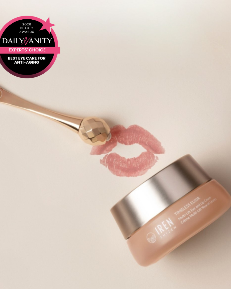 A jar of IREN Shizen TIMELESS ELIXIR Multi-Lift Eye and Lip Cream, a gold facial roller, and a lipstick mark on a light surface with a "Best Eye Care for Anti-Aging" award—perfect for reducing dark circles.