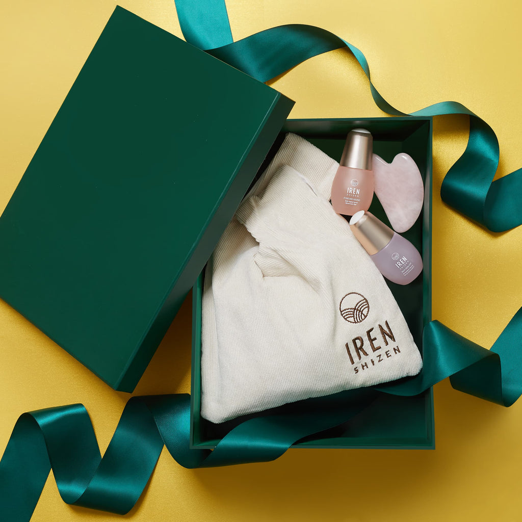 A green gift box with a few items inside.