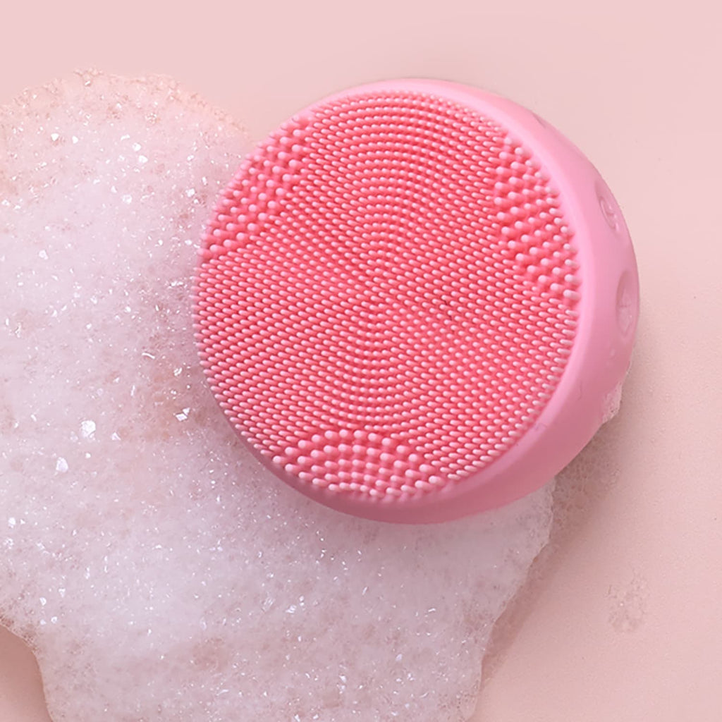 A pink SKIN GENIE PRO Cleansing Brush + LED Light Therapy, offering customised Japanese skincare, sits on top of a pink foam.