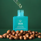 A bottle of IREN Shizen's DROP OF DEW Moisturizing Facial Oil, a customised Japanese skincare product, on a green background. all-groups